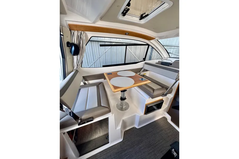 Slide: The Image of Interior of 2021 Cutwater C-24 Coupe, featuring a cozy dining area with seating and table. - 20