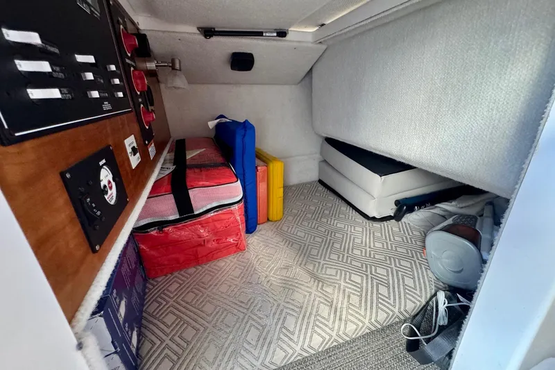 Slide: The Image of 2021 Cutwater C-24 Coupe interior storage area with control panel and organized supplies. - 23