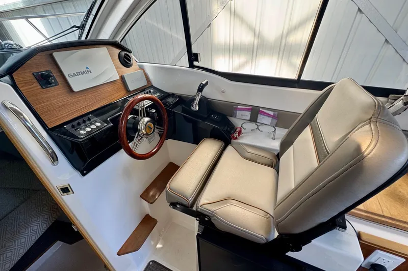 Slide: The Image of 2021 Cutwater C-24 Coupe helm with Garmin navigation, luxurious seating, and modern controls. - 26