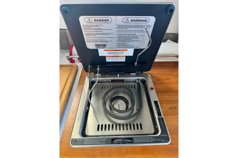 Slide: The Image of Electric stove in 2021 Cutwater C-24 Coupe boat kitchen, featuring safety warnings. - 32