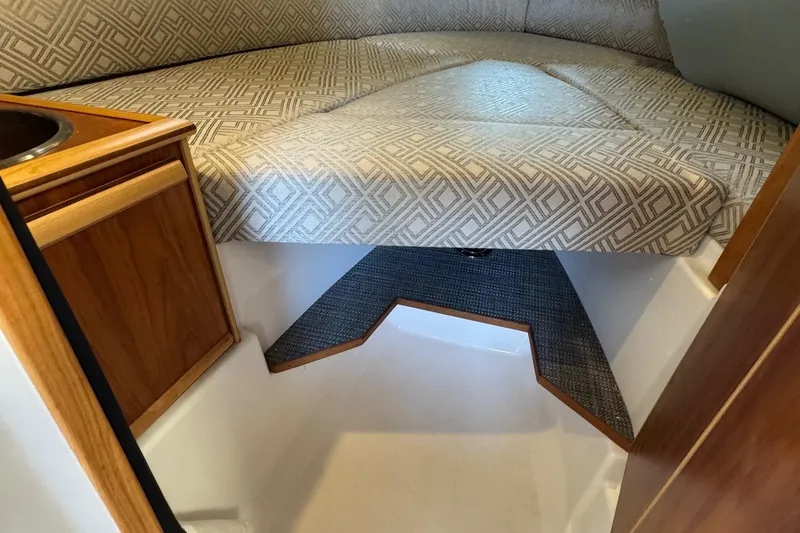 Slide: The Image of 2021 Cutwater C-24 Coupe interior with patterned upholstery and wooden cabinetry. - 37