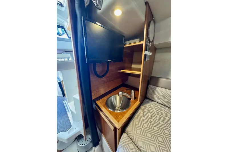 Slide: The Image of 2021 Cutwater C-24 Coupe interior with TV, sink, and cozy seating area. - 39
