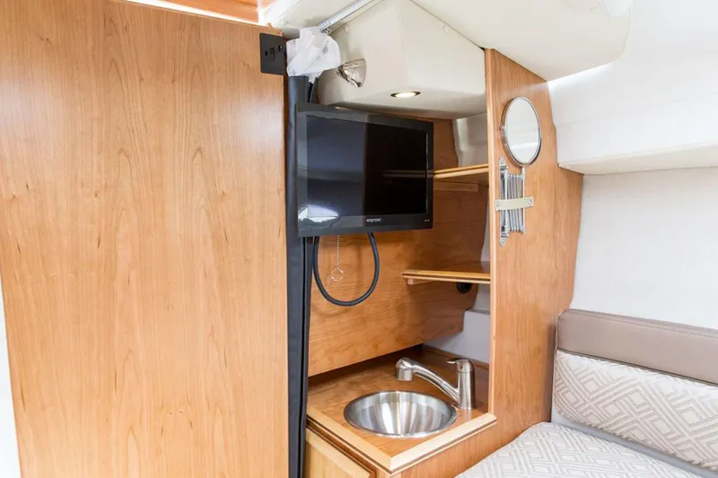 Slide: The Image of Manufacturer Provided Image: 2021 Cutwater C-24 Coupe interior with TV, sink, and wooden cabinetry. - 40