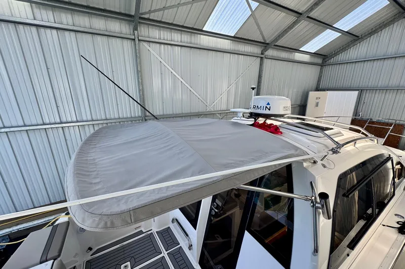 Slide: The Image of 2021 Cutwater C-24 Coupe boat in a metal storage shed, featuring a Garmin radar. - 46