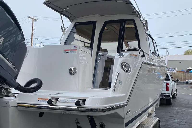 Slide: The Image of 2021 Cutwater C-24 Coupe boat with outboard motor, docked in a marina. - 5