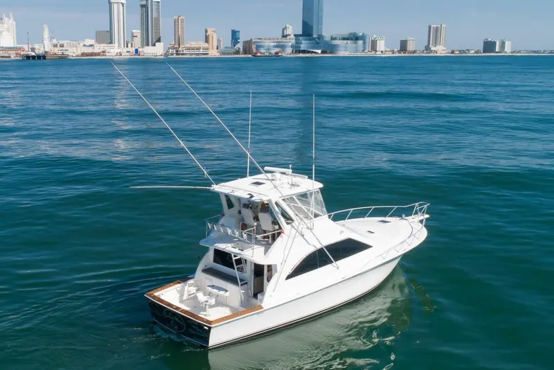 Slide: The Image of Ocean Yachts 48 Super Sport 1999 cruising near city skyline on calm blue waters. - 19