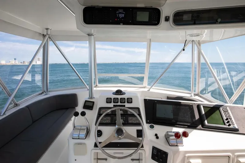 Slide: The Image of 1999 Ocean Yachts 48 Super Sport helm with ocean view, featuring navigation equipment and steering wheel. - 5