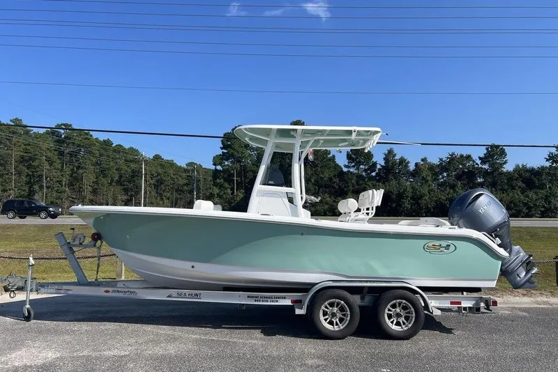 The Image of 2026 Sea Hunt Ultra 219 boat on trailer, parked outdoors under clear blue sky. - 1