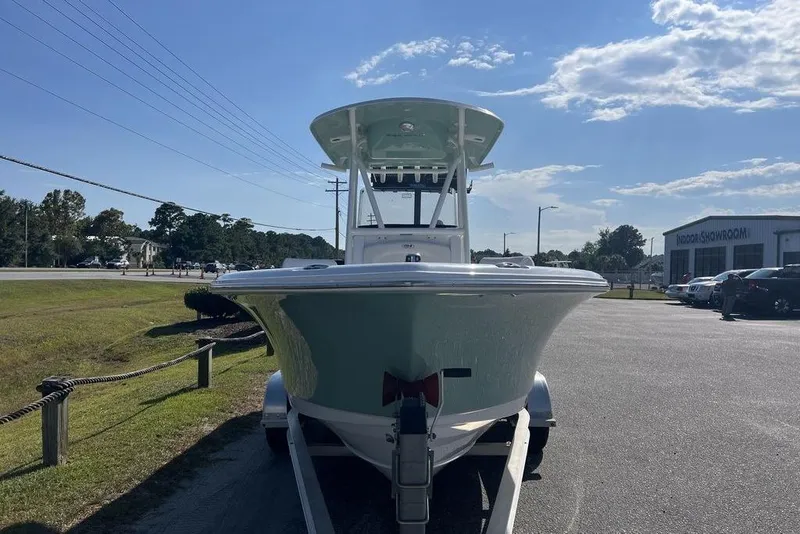 Slide: The Image of 2026 Sea Hunt Ultra 219 boat on trailer, parked outdoors near showroom. - 6