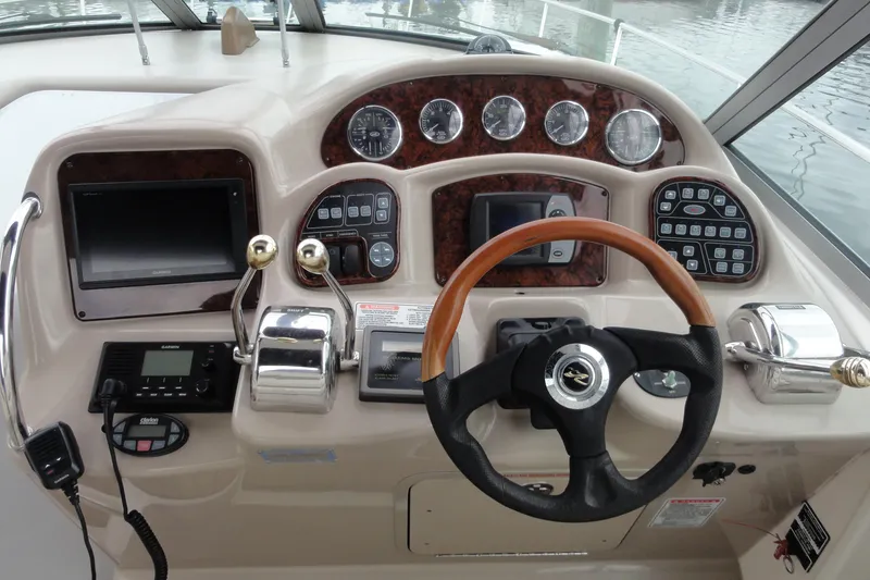 Slide: The Image of Cockpit of 2004 Sea Ray 320 Sundancer with steering wheel and control panel. - 10