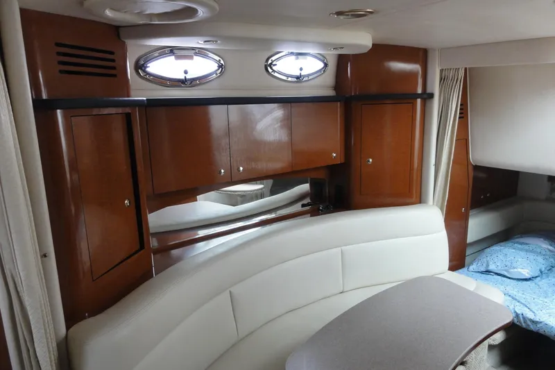 Slide: The Image of Interior of 2004 Sea Ray 320 Sundancer with wood cabinets and white seating. - 17
