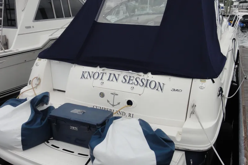 Slide: The Image of 2004 Sea Ray 320 Sundancer boat named "Knot in Session" docked with cover and gear. - 2