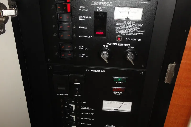 Slide: The Image of Control panel of a 2004 Sea Ray 320 Sundancer boat, showing various switches and gauges. - 24