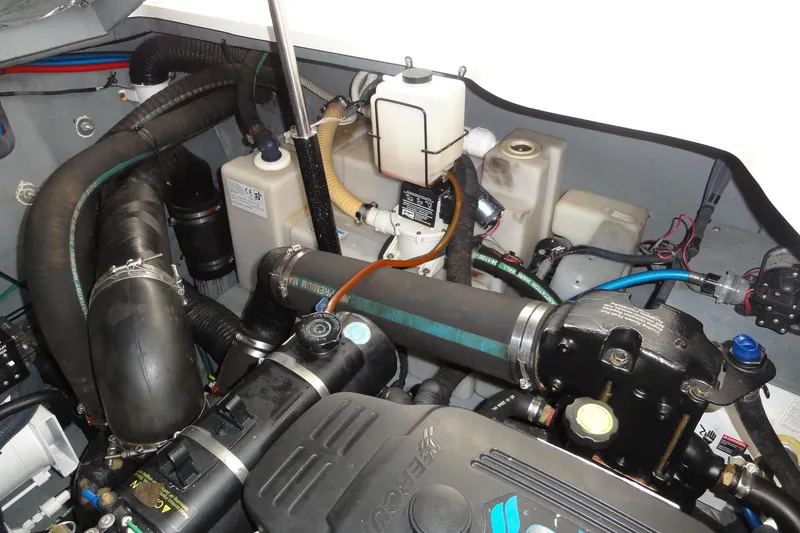 Slide: The Image of Engine compartment of a 2004 Sea Ray 320 Sundancer, showcasing hoses and components. - 29