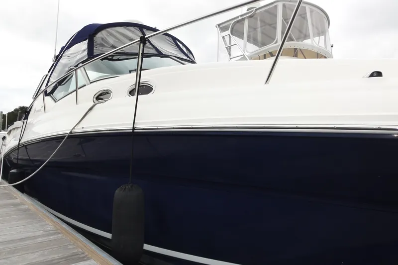 Slide: The Image of 2004 Sea Ray 320 Sundancer docked, featuring sleek design and navy hull. - 7