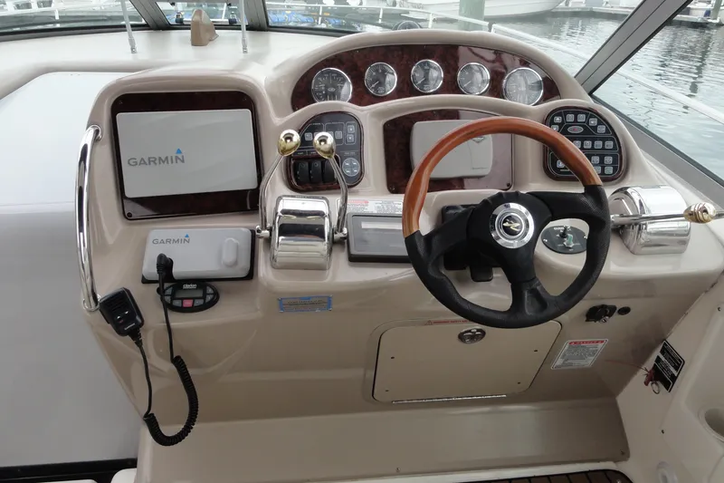 Slide: The Image of 2004 Sea Ray 320 Sundancer helm with Garmin navigation and wood-accented steering wheel. - 9