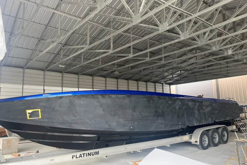 Slide: The Image of 2026 Nor-Tech 390 Sport Center Console boat on trailer, parked outdoors under blue sky. - 16
