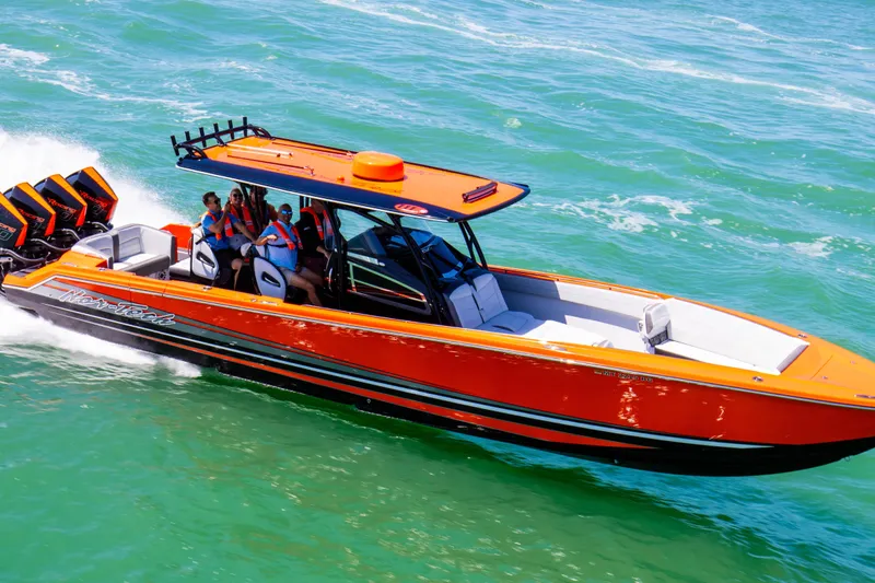 Slide: The Image of 2026 Nor-Tech 390 Sport Center Console speeding on water, vibrant orange design. - 26