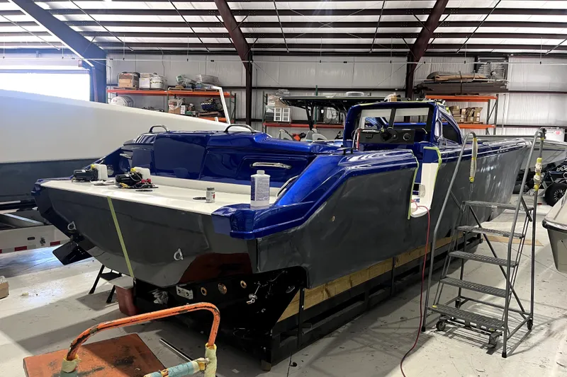 Slide: The Image of 2026 Nor-Tech 390 Sport Center Console boat in a workshop, under construction. - 5