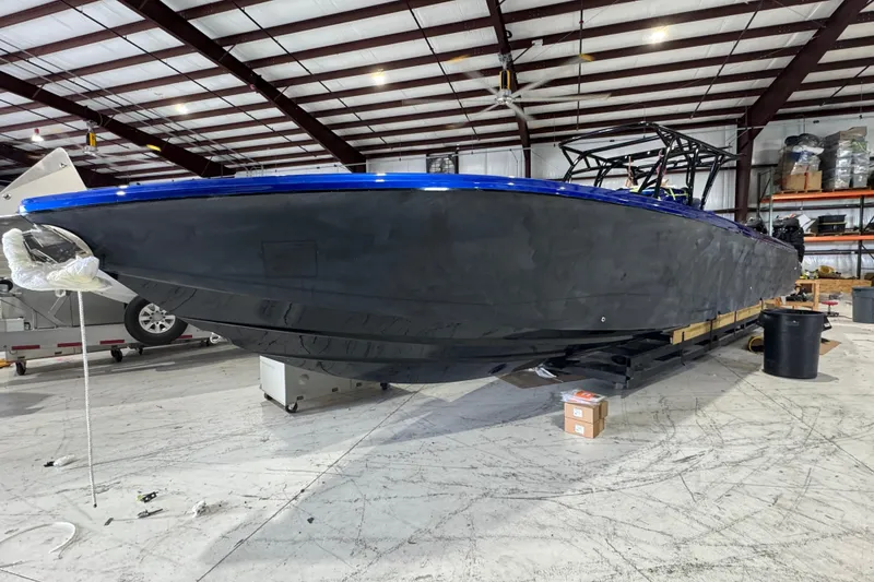 Slide: The Image of 2026 Nor-Tech 390 Sport Center Console boat in a warehouse setting. - 6
