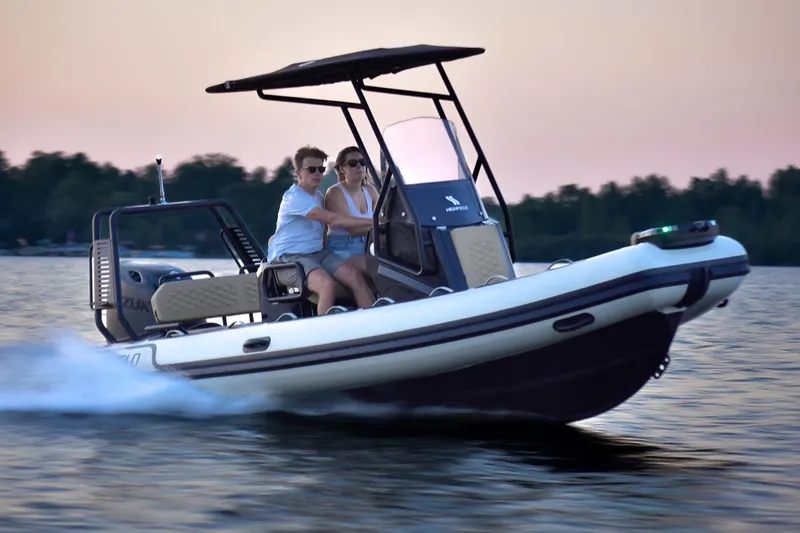 Slide: The Image of 2026 Highfield Sport 560 boat cruising on a lake at sunset with two passengers. - 1