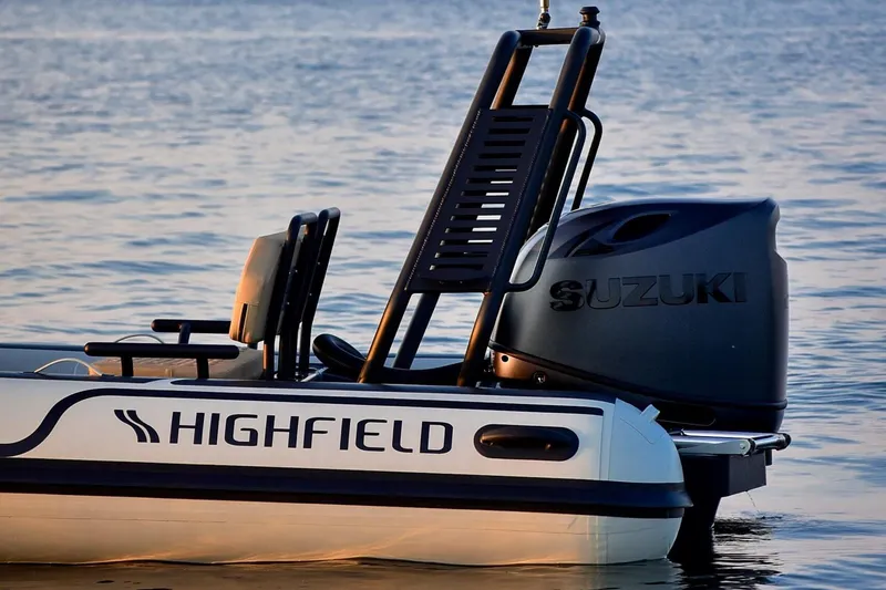 Slide: The Image of 2026 Highfield Sport 560 boat with Suzuki engine on calm water. - 2