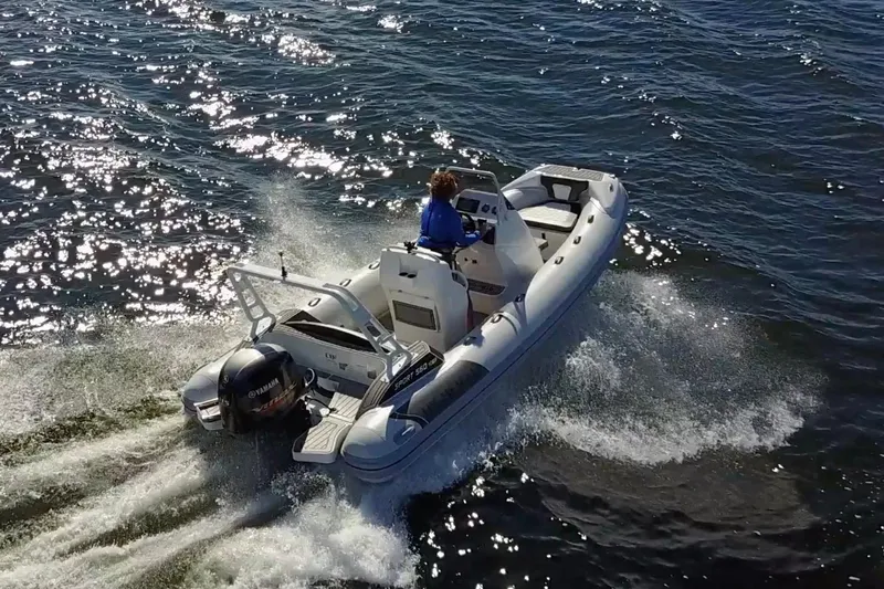 Slide: The Image of 2026 Highfield Sport 560 boat cruising on sparkling water, rear view. - 4