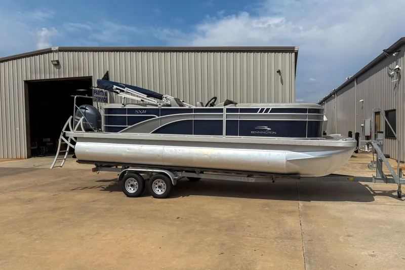 Slide: The Image of 2022 Bennington SX 22 pontoon boat on trailer outside service building. - 3