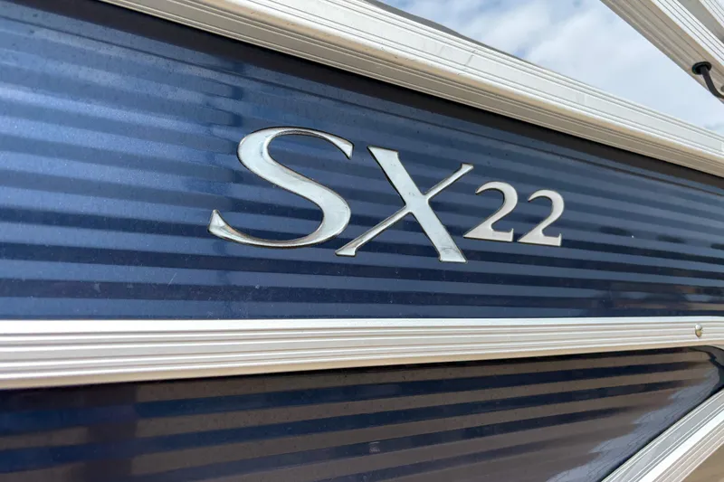 Slide: The Image of 2022 Bennington SX 22 boat logo on a sleek blue surface. - 5