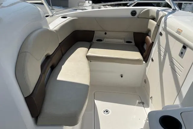 Slide: The Image of 2006 Boston Whaler 320 Outrage Cuddy Cabin interior seating area with beige cushions. - 16