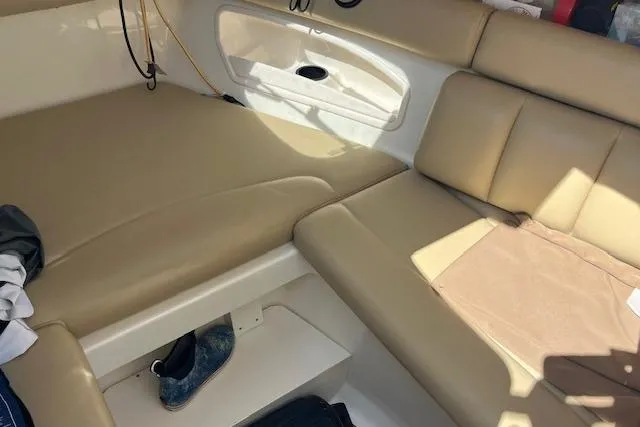 Slide: The Image of 2006 Boston Whaler 320 Outrage Cuddy Cabin interior with beige seating and storage. - 28