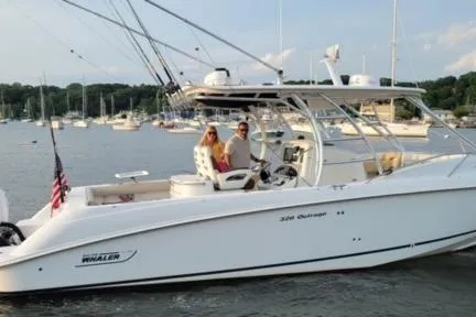 Slide: The Image of 2006 Boston Whaler 320 Outrage Cuddy Cabin on calm waters with two passengers. - 3