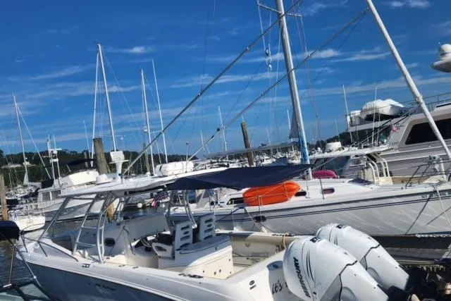 Slide: The Image of 2006 Boston Whaler 320 Outrage Cuddy Cabin docked at a marina under clear blue skies. - 32