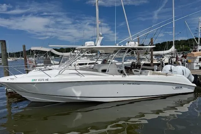 Slide: The Image of 2006 Boston Whaler 320 Outrage Cuddy Cabin docked in a marina under a clear sky. - 7