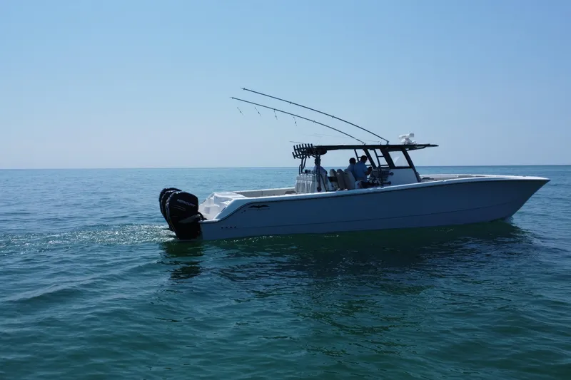 Slide: The Image of 2022 Invincible 46 Catamaran cruising on open water under clear blue skies. - 18