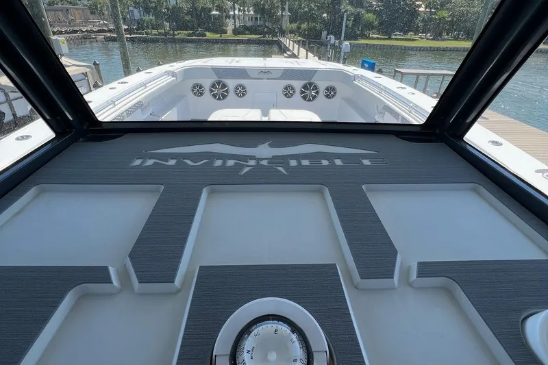 Slide: The Image of 2022 Invincible 46 Catamaran with sleek design and modern audio system, docked by waterfront. - 30