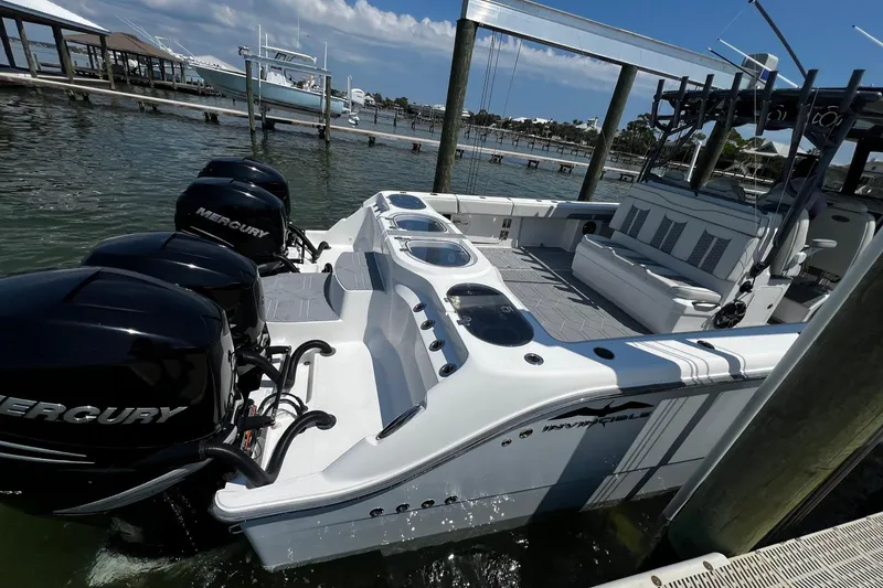 Slide: The Image of 2022 Invincible 46 Catamaran with Mercury engines docked under a clear blue sky. - 35