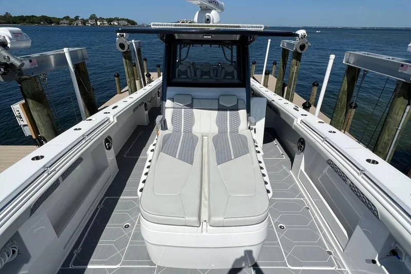 Slide: The Image of 2022 Invincible 46 Catamaran with powerful outboard engines docked by the water. - 47