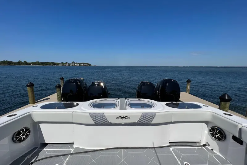 Slide: The Image of 2022 Invincible 46 Catamaran deck with seating, ocean view, and multiple outboard engines. - 56
