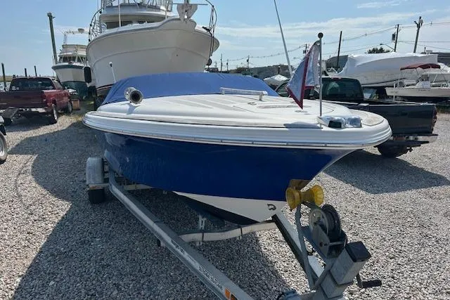 Slide: The Image of 2005 Chris-Craft Speedster boat on trailer, blue hull, parked on gravel lot. - 4