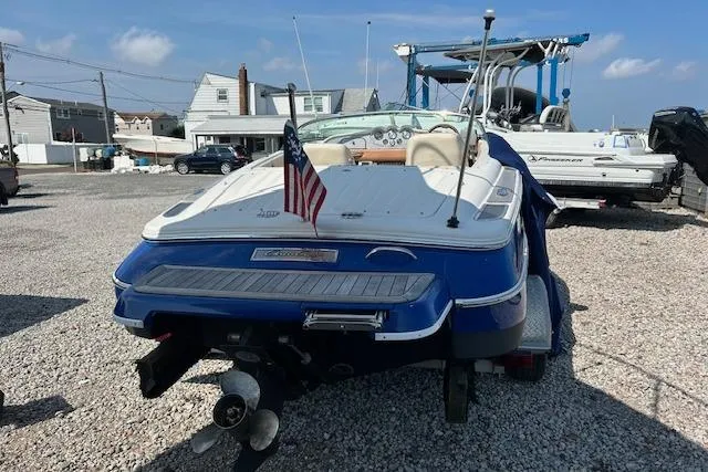 Slide: The Image of 2005 Chris-Craft Speedster boat with American flag, parked on gravel lot. - 5