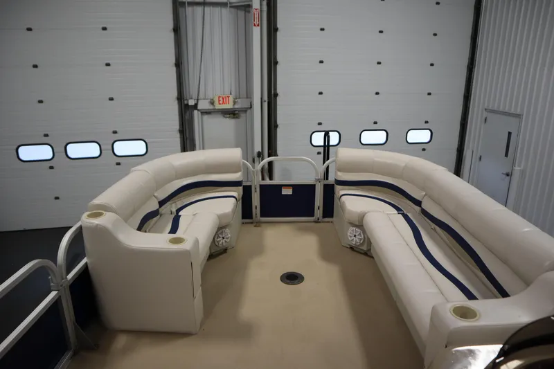 Slide: The Image of 2014 Sun Tracker Party Barge 24 DLX interior with spacious seating in a garage setting. - 10