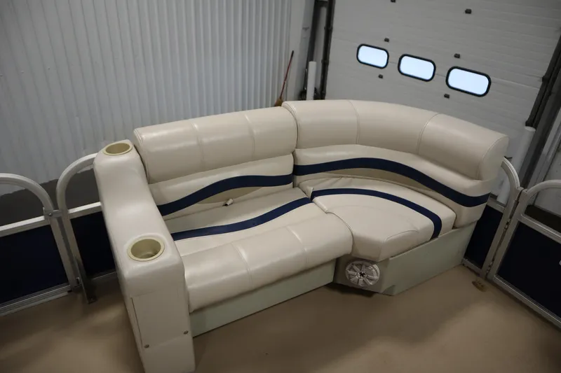 Slide: The Image of 2014 Sun Tracker Party Barge 24 DLX interior seating with cup holders in a garage. - 11