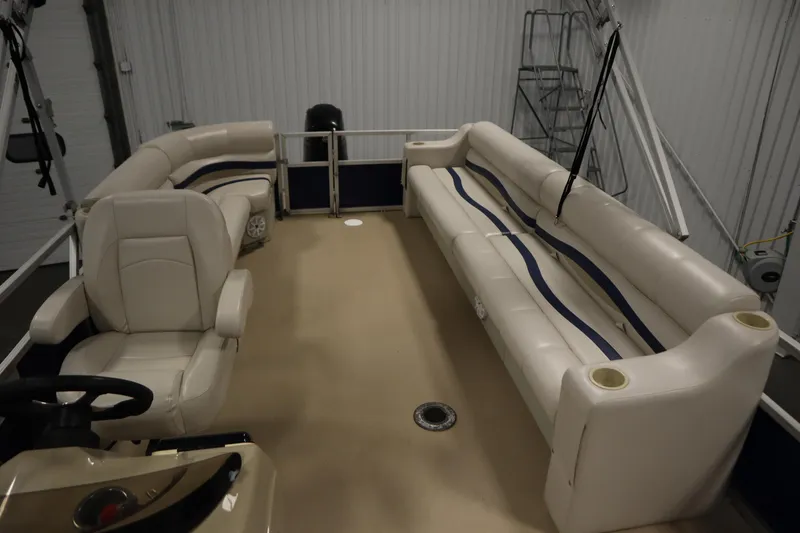 Slide: The Image of 2014 Sun Tracker Party Barge 24 DLX interior with beige seating and steering console. - 24