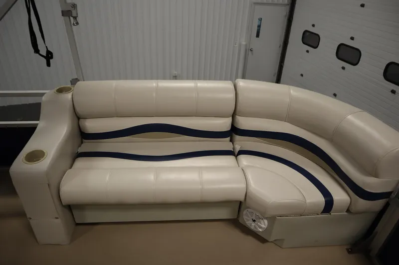 Slide: The Image of 2014 Sun Tracker Party Barge 24 DLX interior seating with cup holders in a garage. - 27
