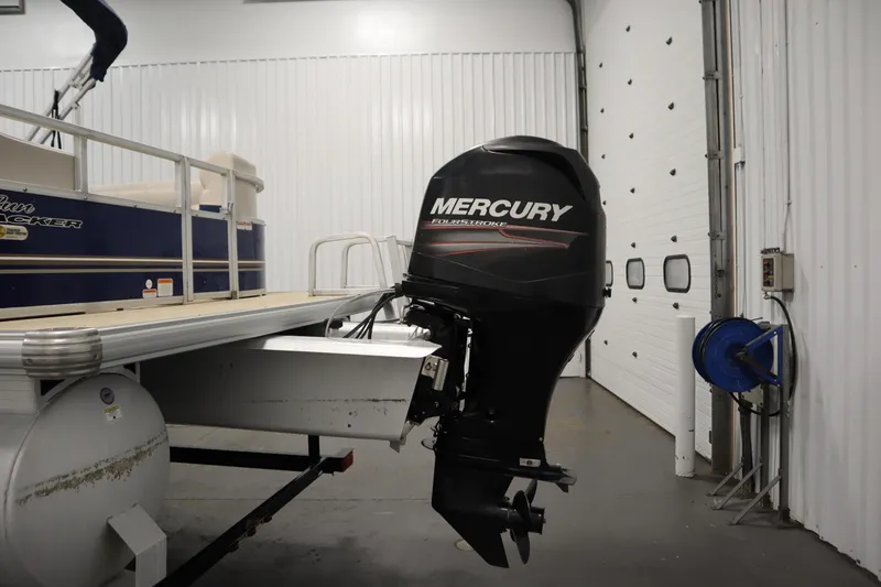 Slide: The Image of 2014 Sun Tracker Party Barge 24 DLX with Mercury outboard motor in a garage. - 30