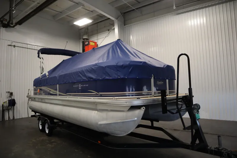 Slide: The Image of 2014 Sun Tracker Party Barge 24 DLX pontoon boat with blue cover in indoor storage. - 39