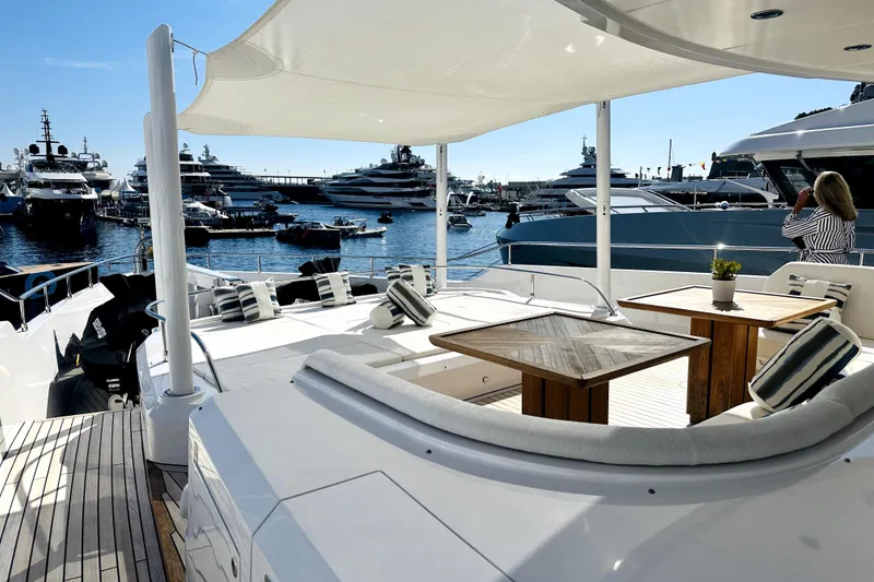 Slide: The Image of Luxurious 2023 Majesty 120 yacht deck with elegant seating, overlooking marina filled with yachts. - 4