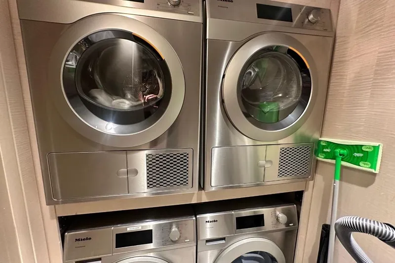 Slide: The Image of Stacked Miele laundry machines in a compact space, featuring a 2024 Majesty 120 model. - 50