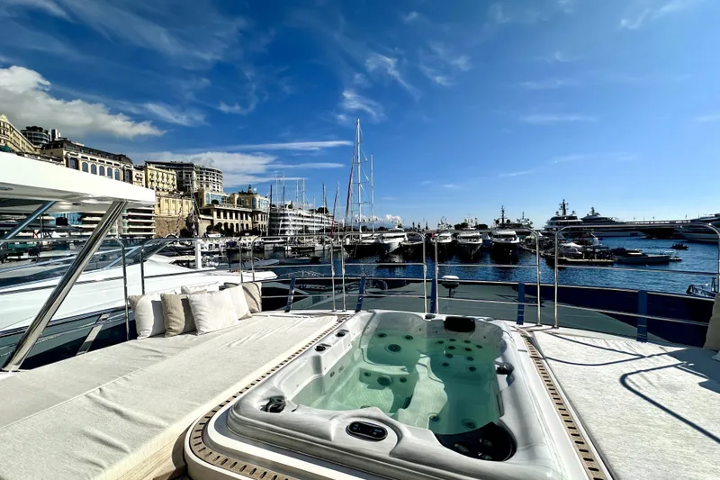 Slide: The Image of Luxurious 2023 Majesty 120 yacht with jacuzzi, docked in a scenic marina. - 6